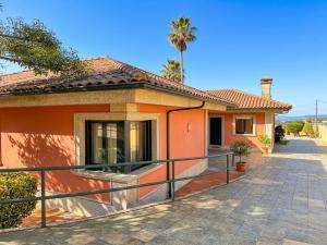a small orange house with a fence in front of it at La Pepa Sanxenxo in Sanxenxo +19 photos