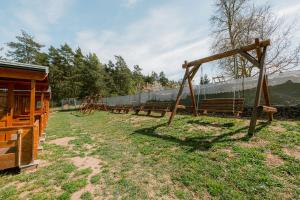 a row of wooden playground equipment in a field at U Bernarda in Slavíkovice
