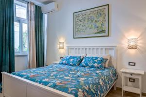 a bedroom with a bed with a blue comforter at Cozy guest house Downtown in Olbia