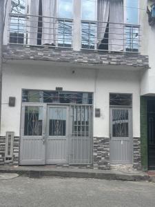 a white building with doors and windows on it at Apartamento amoblado Chinchina in Chinchiná