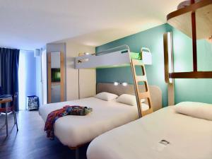 a room with two beds and a bunk bed at ibis budget Vannes in Vannes +44 photos