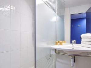 a white bathroom with a sink and a shower at ibis budget Bayonne in Bayonne +59 photos