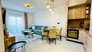 a living room with a blue couch and a table at Apartman Romanija Wellness & Spa in Potoci