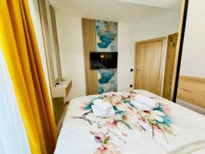 a bedroom with a bed with flowers on it at Apartman Romanija Wellness & Spa in Potoci +13 photos