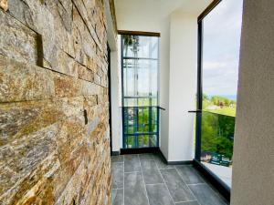 a room with a stone wall and a window at Apartman Romanija Wellness & Spa in Potoci