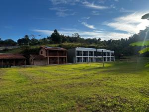 a large building with a field in front of it at Pousada Natalino Broleze in Águas de Lindoia