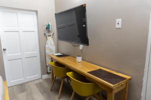 ein Zimmer mit Schreibtisch, Stühlen und Fernseher in der Unterkunft Comfi Spaces in Canaan