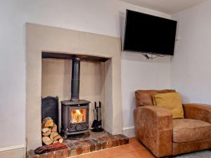 a living room with a wood stove and a chair at 1 Bed in Matlock oc-75400 in Middleton