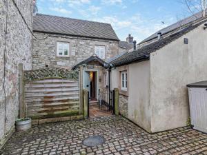 an old stone house with a gate and a garage at 1 Bed in Matlock oc-75400 in Middleton
