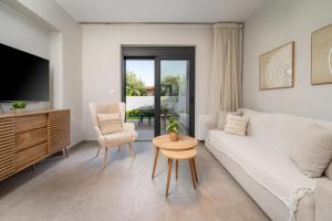 a living room with a white couch and a table at Luxe benedenwoning Nula Kos in Kos