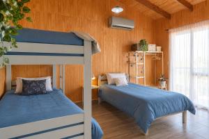 two beds in a room with wooden walls at keca home Misiones, pileta, patio y Posadas a 20 minutos in Candelaria +37 photos