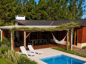 a backyard with a pool and chairs and a house at keca home Misiones, pileta, patio y Posadas a 20 minutos in Candelaria