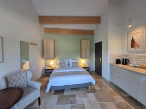 a bedroom with a bed and a couch and a chair at Le Bos Dordogne in Soulaures