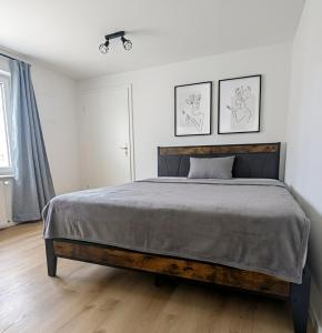 a bedroom with a bed and two pictures on the wall at Ferienwohnung Hoffmann in Radebeul