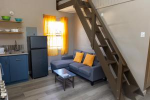 ein Wohnzimmer mit Sofa und Treppe in der Unterkunft Comfi Spaces in Canaan