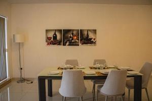 a dining room table with chairs and a table with wine glasses at Modern 3 bedroom with AC apartment in Żabbar