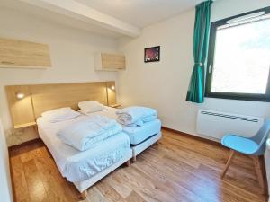 a bedroom with two beds and a chair and a window at Lia, T3, au calme, parking, internet in Luchon