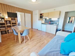 a living room with a table and a kitchen at Lia, T3, au calme, parking, internet in Luchon +14 photos