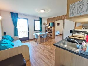 a kitchen and living room with a couch and a sink at Lia, T3, au calme, parking, internet in Luchon