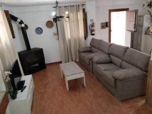 a living room with a couch and a stove at Casa Rural La Encina 2 in Lanjarón