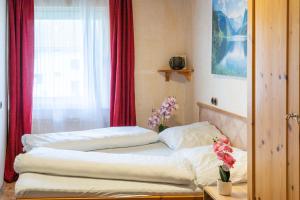 a bedroom with two beds and a window with red curtains at Naturparadies Nähe Grüner See in Oberdorf