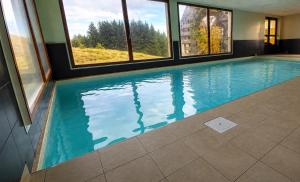 a large swimming pool with windows in a building at Le Nid du Sancy - Les Matins du Sancy - Super-Besse in Super Besse