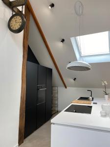 eine Küche mit schwarzen Schränken und einer Uhr an der Wand in der Unterkunft Chez Arli in Attert + 42 Fotos
