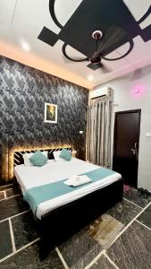a bedroom with a bed with a ceiling fan at Hotel Madhav Inn in Lucknow +2 photos