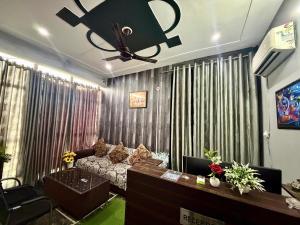 a living room with a couch and a ceiling fan at Hotel Madhav Inn in Lucknow