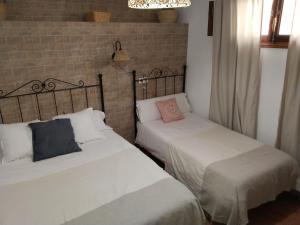 two beds sitting next to each other in a room at Casa Rural La Encina 2 in Lanjarón +9 photos