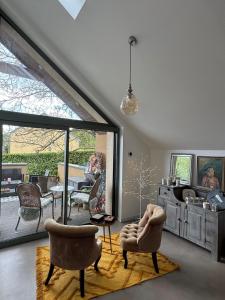 ein Wohnzimmer mit Stühlen und einer Glasschiebetür in der Unterkunft Chez Arli in Attert