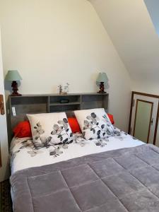 a bedroom with a large bed with red pillows at Les coccinelles bretonnes in Plouescat