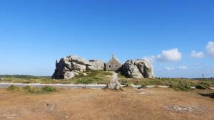 a group of rocks and a building in a field at Les coccinelles bretonnes in Plouescat +1 photo