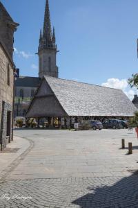 a large building with a clock tower and a church at Les coccinelles bretonnes in Plouescat