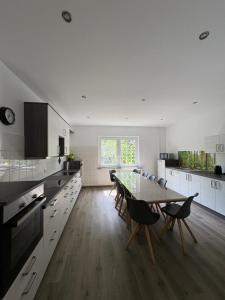 a large white kitchen with a table and chairs at An der Gärtnerei in Dömitz