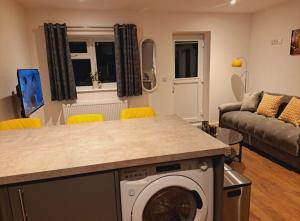 a kitchen and living room with a washing machine at Yew Tree Retreat- Sunset Suite in Newbury