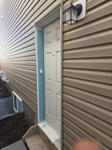a door on the side of a house at Modern 2-Bedroom Private Basement Apartment in Airdrie +17 photos