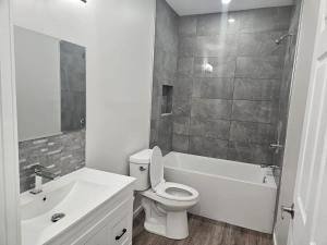 a white bathroom with a toilet and a sink at Modern 2-Bedroom Private Basement Apartment in Airdrie