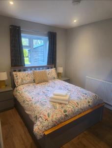 a bedroom with a bed with two towels on it at Yew Tree Retreat- Sunset Suite in Newbury