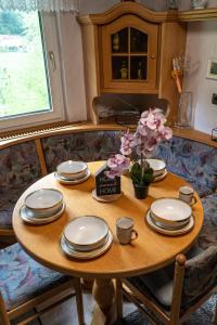 a wooden table with plates and cups and flowers on it at Naturparadies Nähe Grüner See in Oberdorf