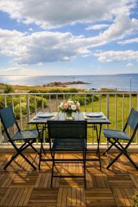 a table and chairs on a deck with a view of the ocean at Studio cosy avec terrasse, vue mer in Quiberon
