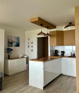 a kitchen with white cabinets and wooden counters at Studio cosy avec terrasse, vue mer in Quiberon