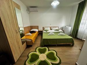 a room with two beds and a green flower rug at Casa Enka in Tuzla +16 photos