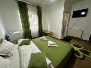 a hotel room with two beds with green sheets at Casa Enka in Tuzla