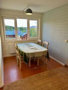 a dining room with a table and chairs and windows at Halek Hem - Haga Nest in Haga