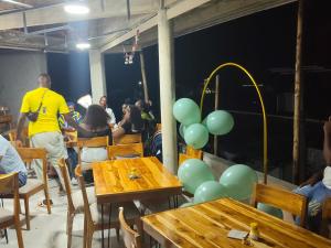 a group of people sitting at tables with balloons at Hotel Riviera del Atrato in Bojayá +16 photos