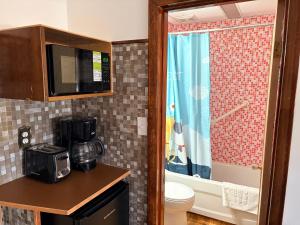 a bathroom with a toilet and a microwave at Heritage Place Hotel in Gravelbourg