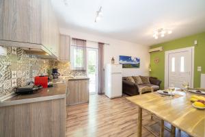 a kitchen and living room with a table and a couch at Orchid Garden Apartment in Sami +32 photos