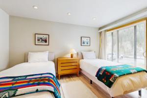 two beds in a room with a window at Mountain Magic in Ketchum