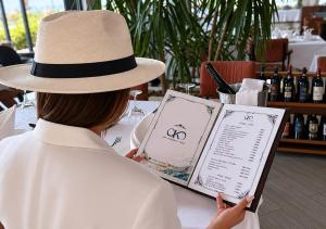 a woman sitting at a table wearing a hat at OKEJ Hotel in Golem